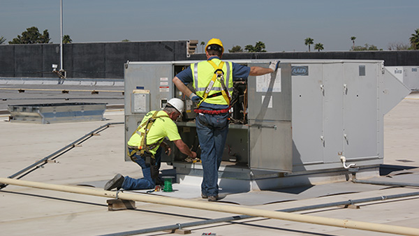 Workers installing equipment at a Walmart location, showing the installation process and tools used.